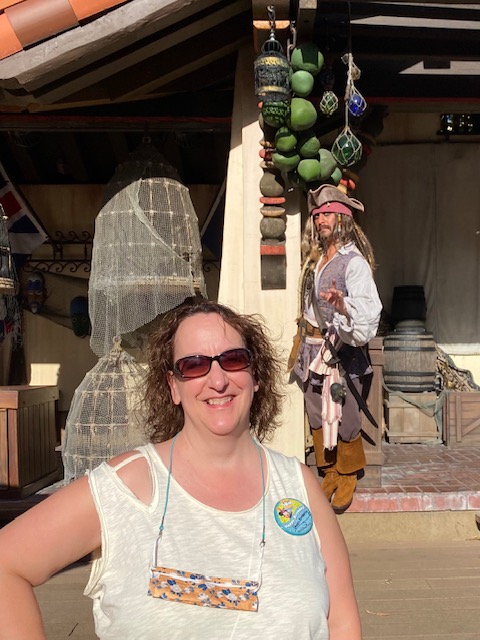 The author at Walt Disney World with the character Captain Jack Sparrow in the background.